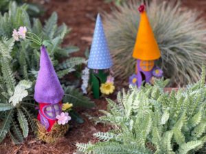 Fairy houses made from toilet paper rolls in garden.