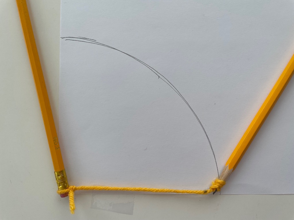 To make the roof, use two pencils, tied with yarn. Keep one stationary, then swing the second pencil around in an arc.
