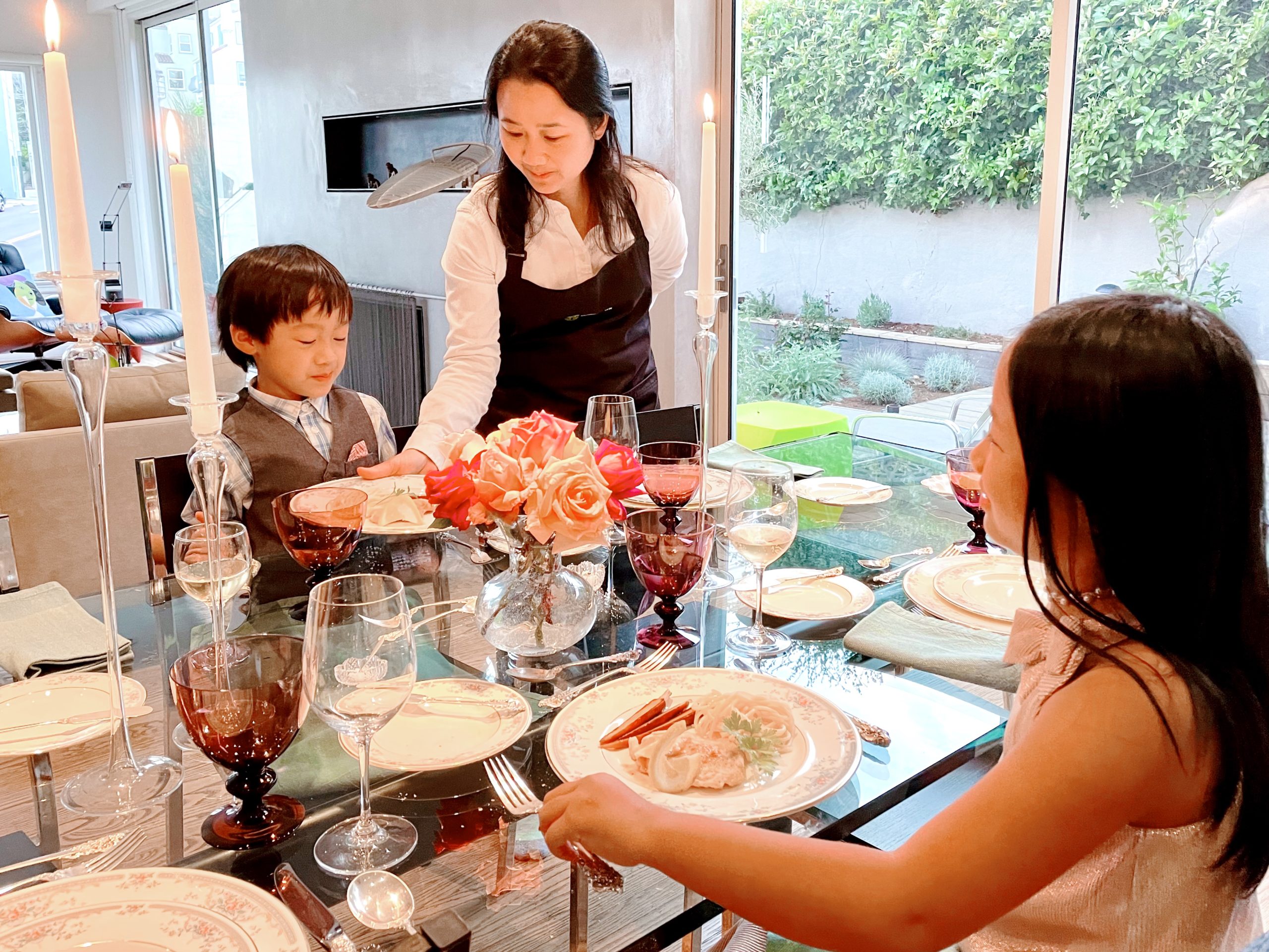 Mom seerves the kids at this pretend restaurant to teach dining etiquette.