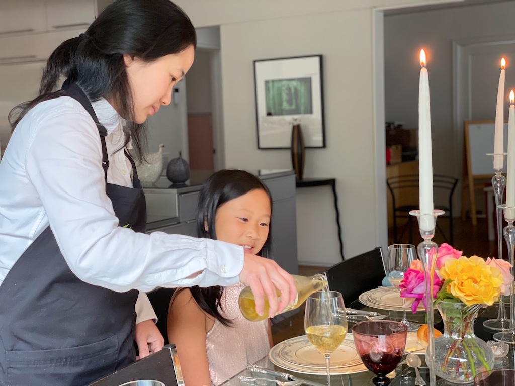 Mom as server pours her daughter sparkling apple cider.