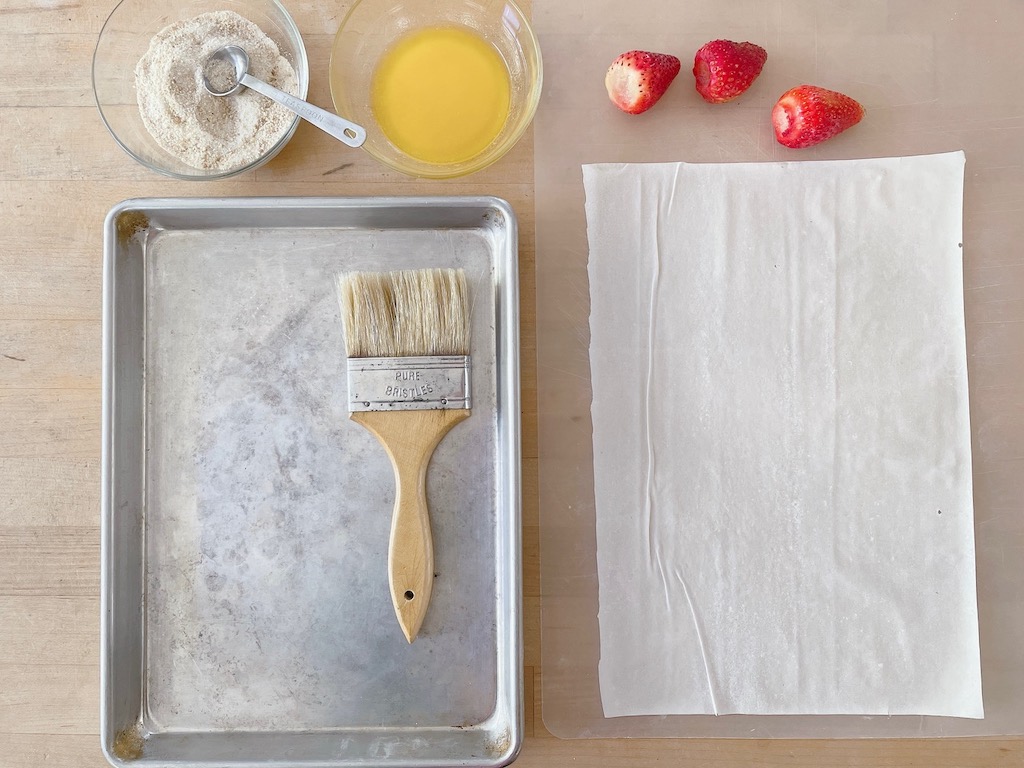 The mise en place: breadcrumbs mixed with sugar, melted butter, hulled strawberries and a phyllo sheet.