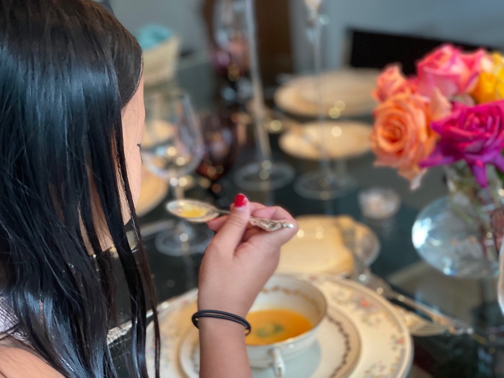 Dining etiquette for kids: child sips her soup from the side of the spoon.