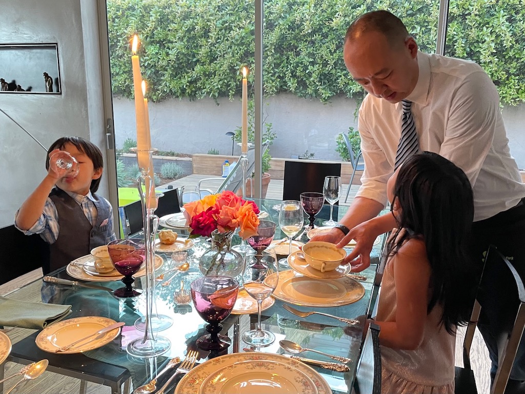 Dad busses the soup dishes.