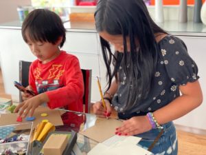 Kids making Father's Day gift notebooks.