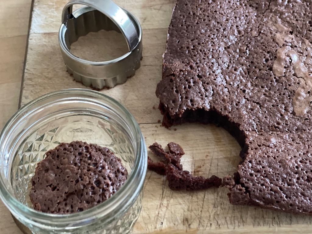 Cut circles from a pan of brownies using a biscuit cutter to line the bottom and top of a mini mason jar.