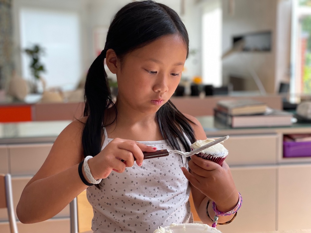 Frosting the cupcakes is the first step to make high heel cupcakes. Each step, done successfully, helps to build confidence in a child.