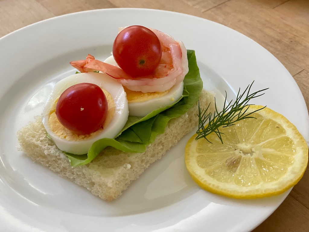 Part of a pretend trip is to prepare foods of the country we are "visiting." Miss T's Swedish open-faced sandwich is garnished with a lemon slice and a sprig of dill.