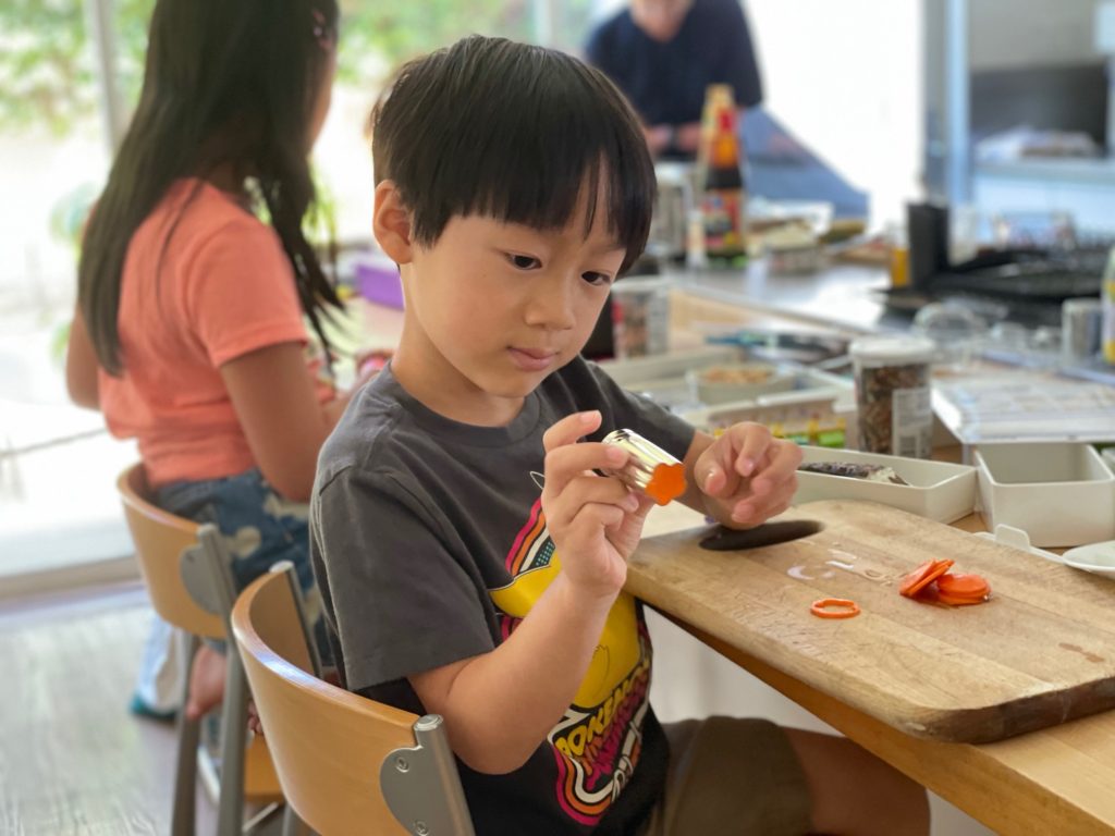 Little N cuts carrots into flowers for his bento lunch. Normally, he might not eat a carrot stick, but who can resist a carrot flower? Especially one he cut himself.