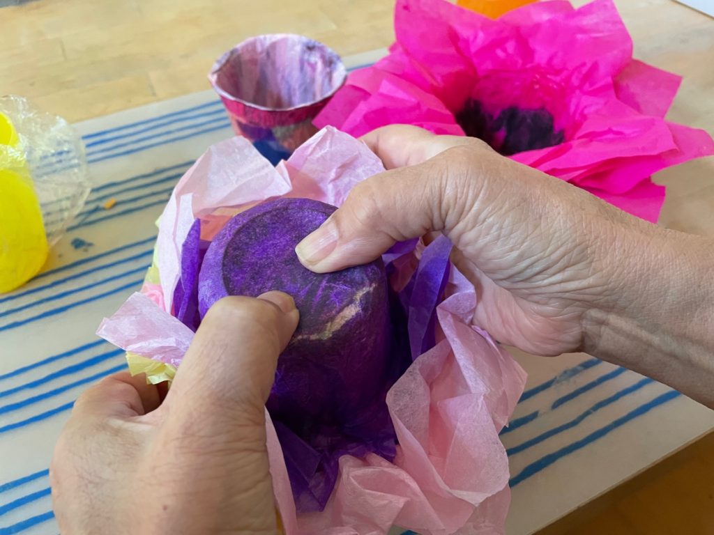 To release tissue paper bowl, hold the bottom of the bowl with thumbs and gently push the tissue paper out of the bowl.
