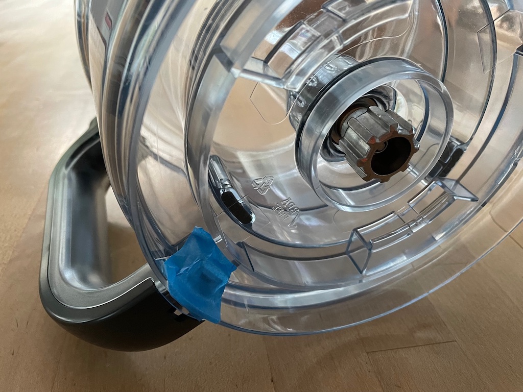 Cover exposed holes of food processor bowl and lid where the unit locks into place, with blue painter's tape. It will keep water from seeping into the handle when washing.