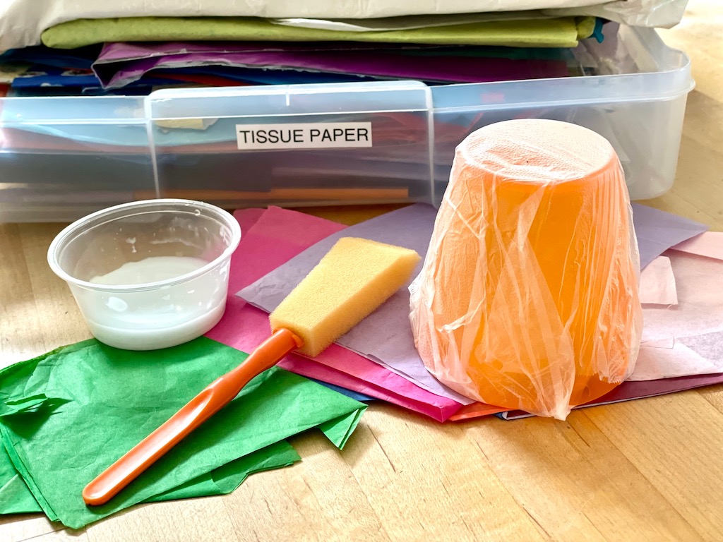 To make tissue paper bowls, cover a cup or bowl with plastic wrap and use it as a mold.