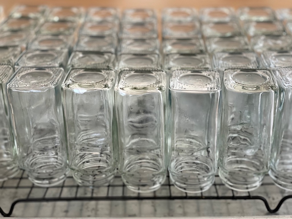 New spice bottles set on a rack to dry.