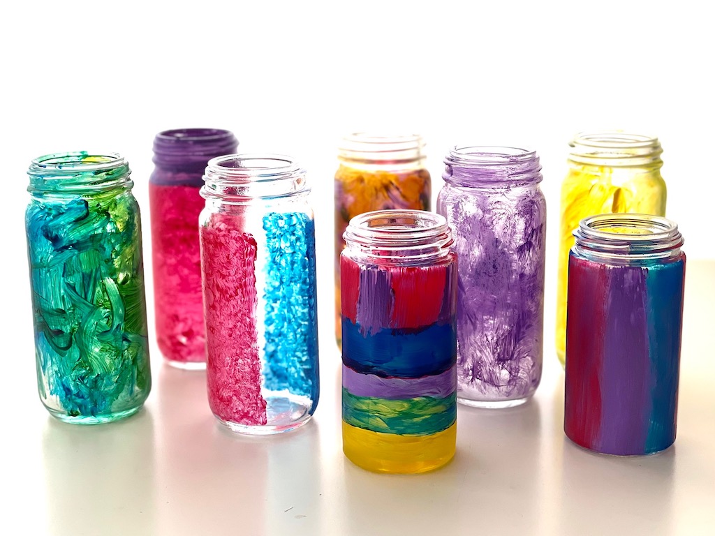 Discarded spice jars are painted, to be used as flower vases.