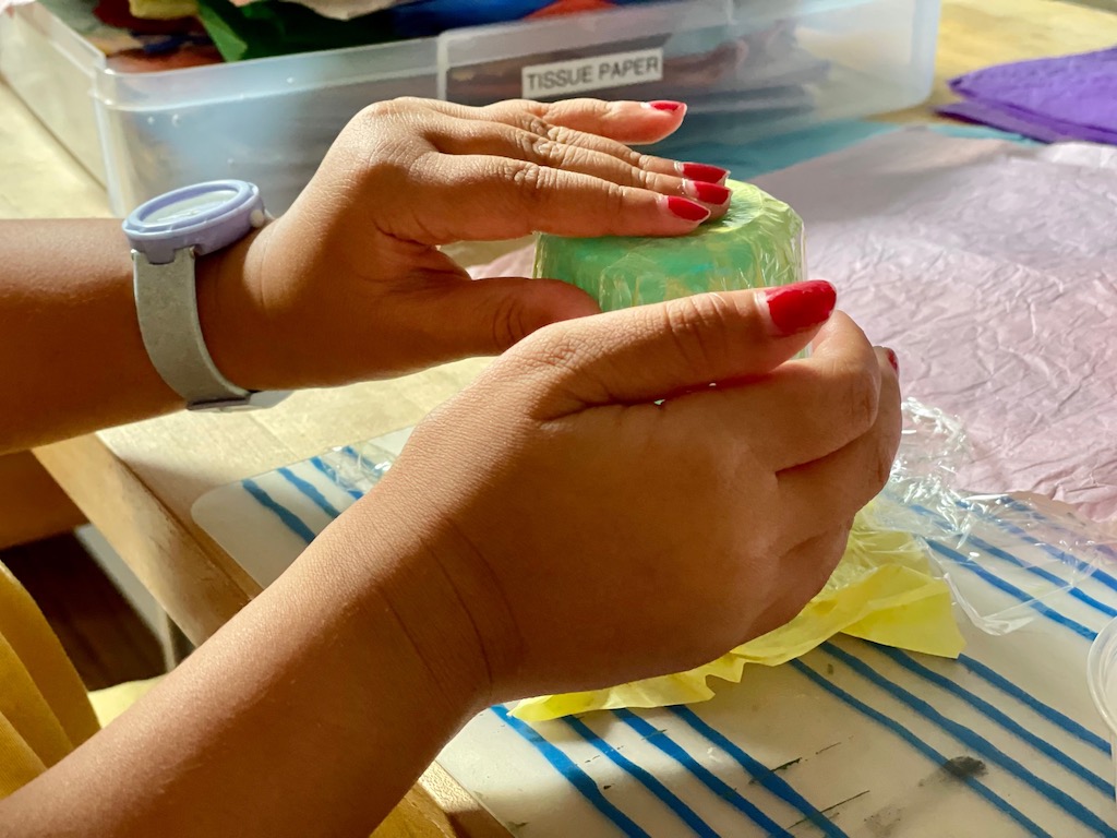 Press a layer of tissue paper over the mold and continue to add layers.