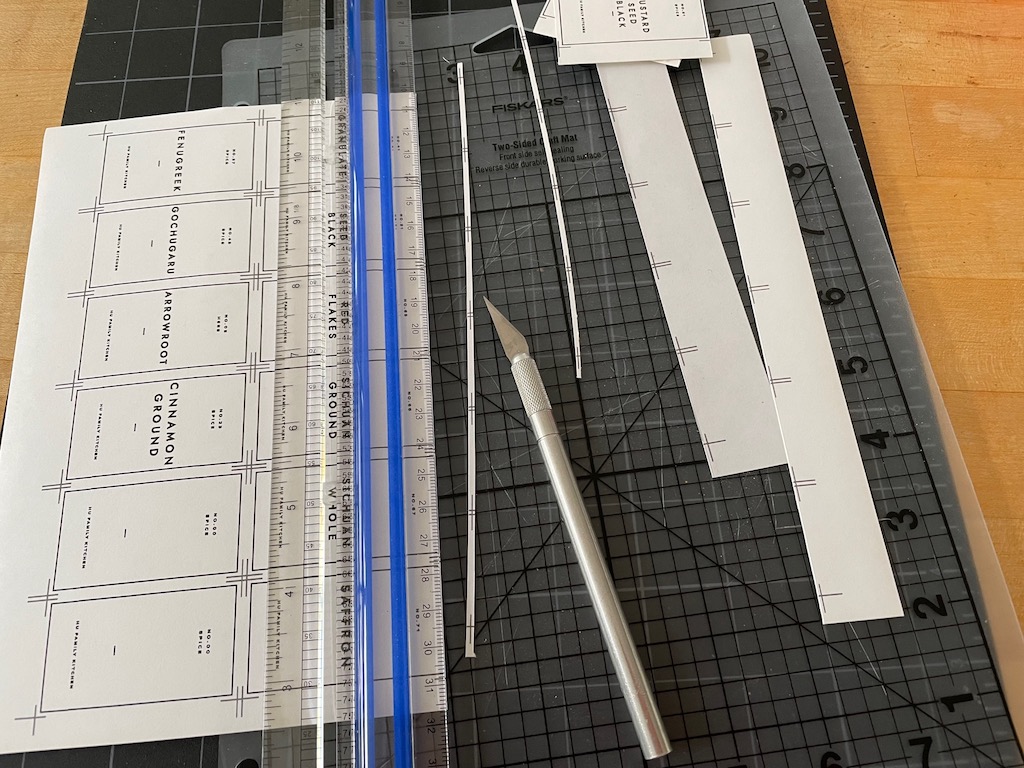 Cut labels with an X-ACTO knife and clear plastic ruler on a self-healing cutting mat.
