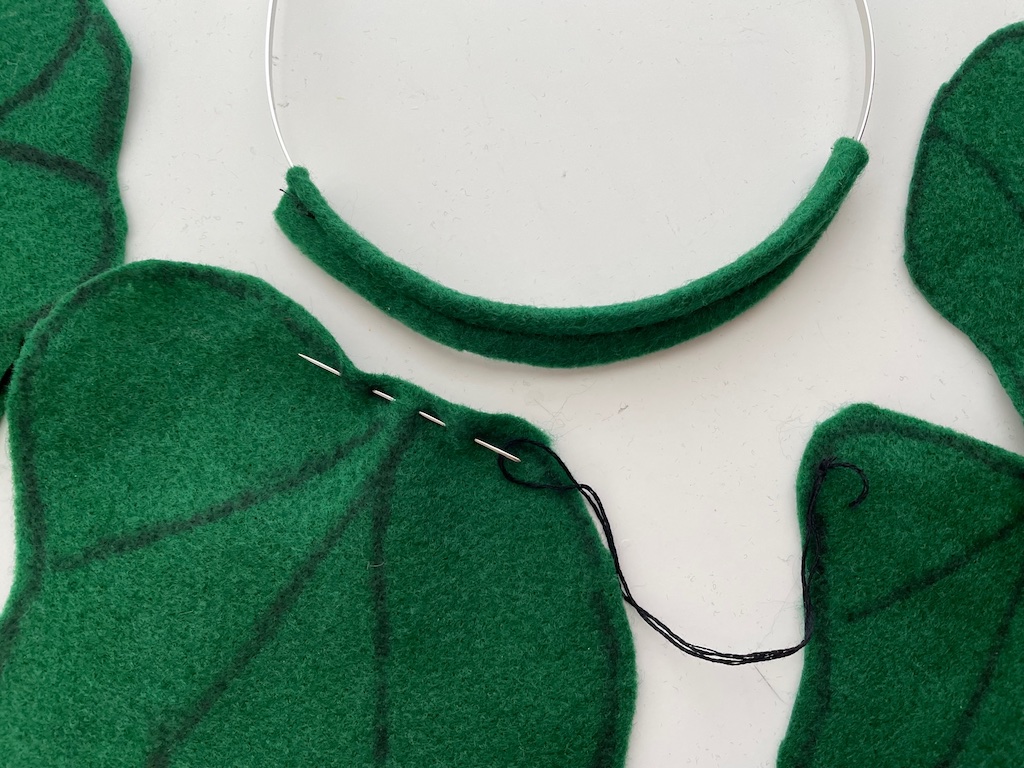 Use a running stitch at the base of each leaf and gather; stitch to the headband.