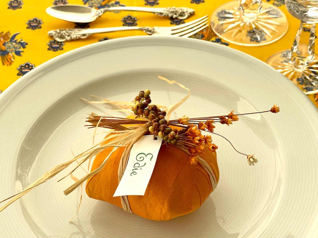 Turn a surprise ball into a place card and party favor for a dinner party. This ball is decorated with straw flowers and berries for Thanksgiving.