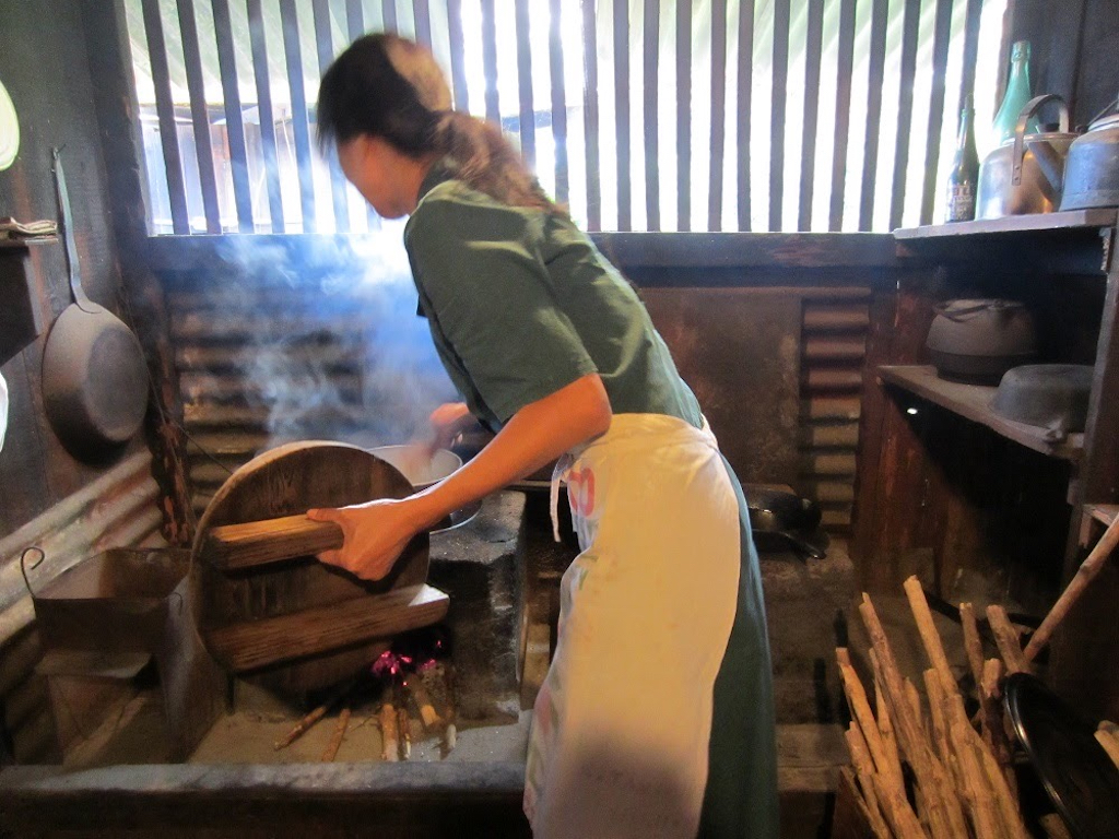 Demonstration of cooking rice on a stove fueled by setting fire to branches at the Kona Coffee Living History Farm. 