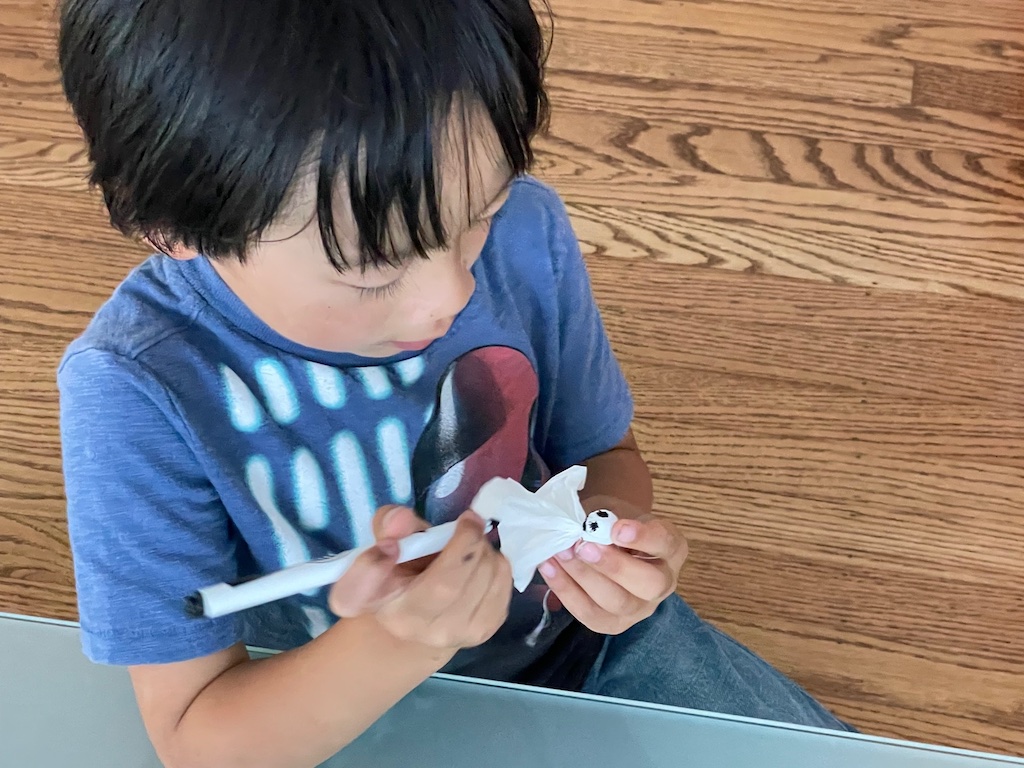 To make ghosts, wrap a pom pom in tissue and tie around the neck. Make features with a marking pen.