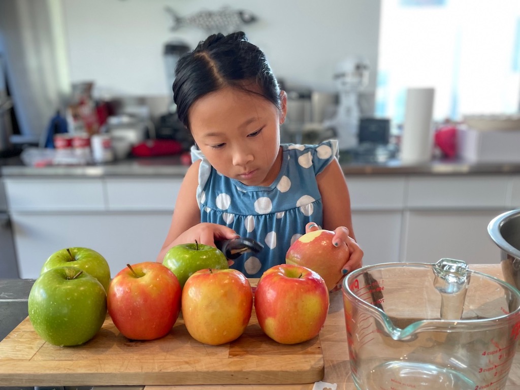 Child peeling apples for pie.