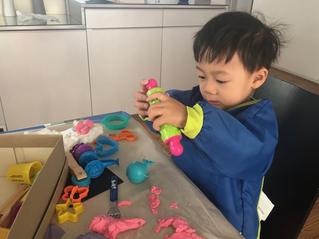 Child playing with Play-Doh cutting and shaping tools. Grandma advice: give these easy-to-use toys to a family shelter.