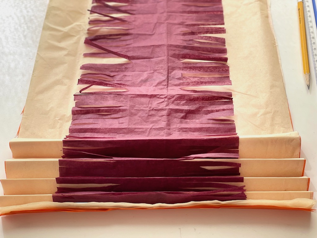 Accordion-fold tissue paper from the short side in 1-inch folds.