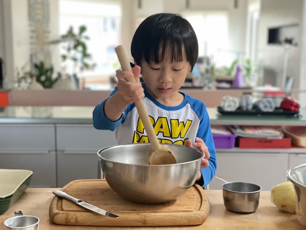 Child stirs topping ingredients to make Easy Apple Crisp.