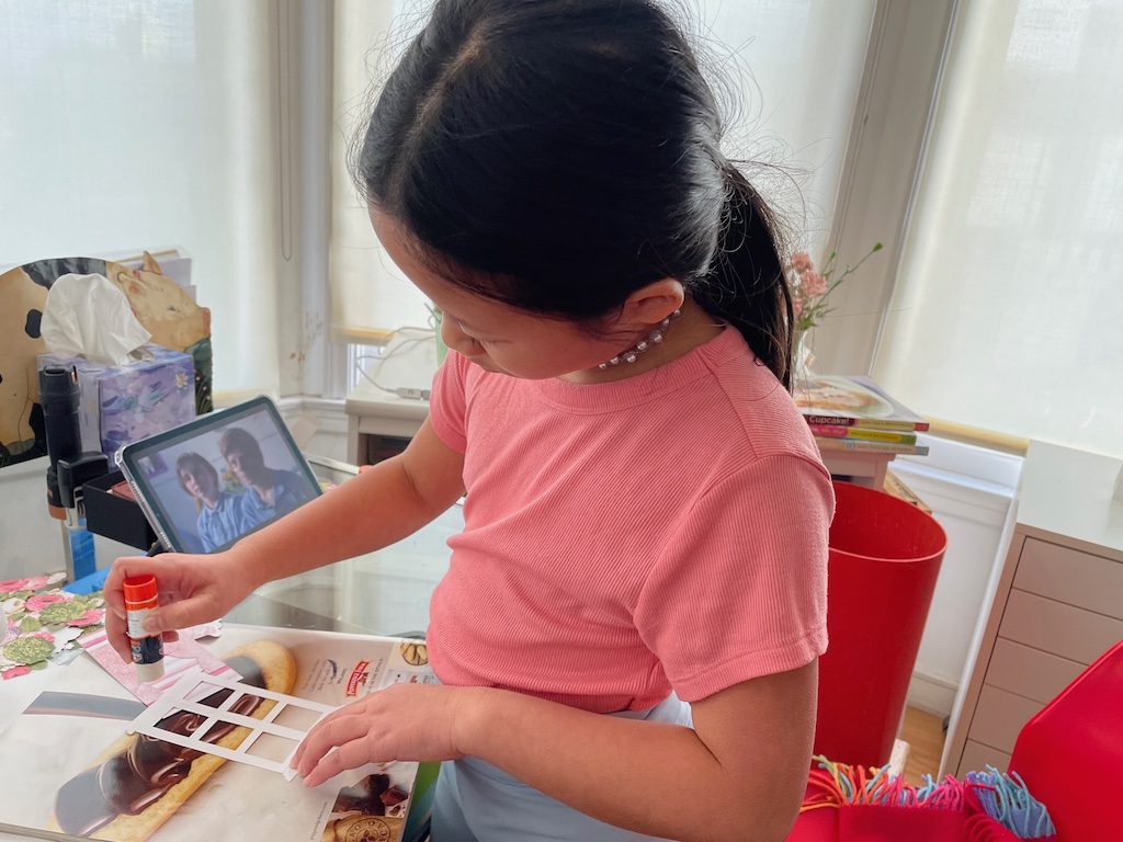 Child glues down elements for a greeting card.