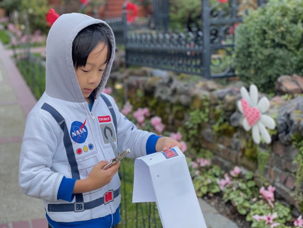 Child on a scavenger hunt. He punches a hole next to the image he has found.