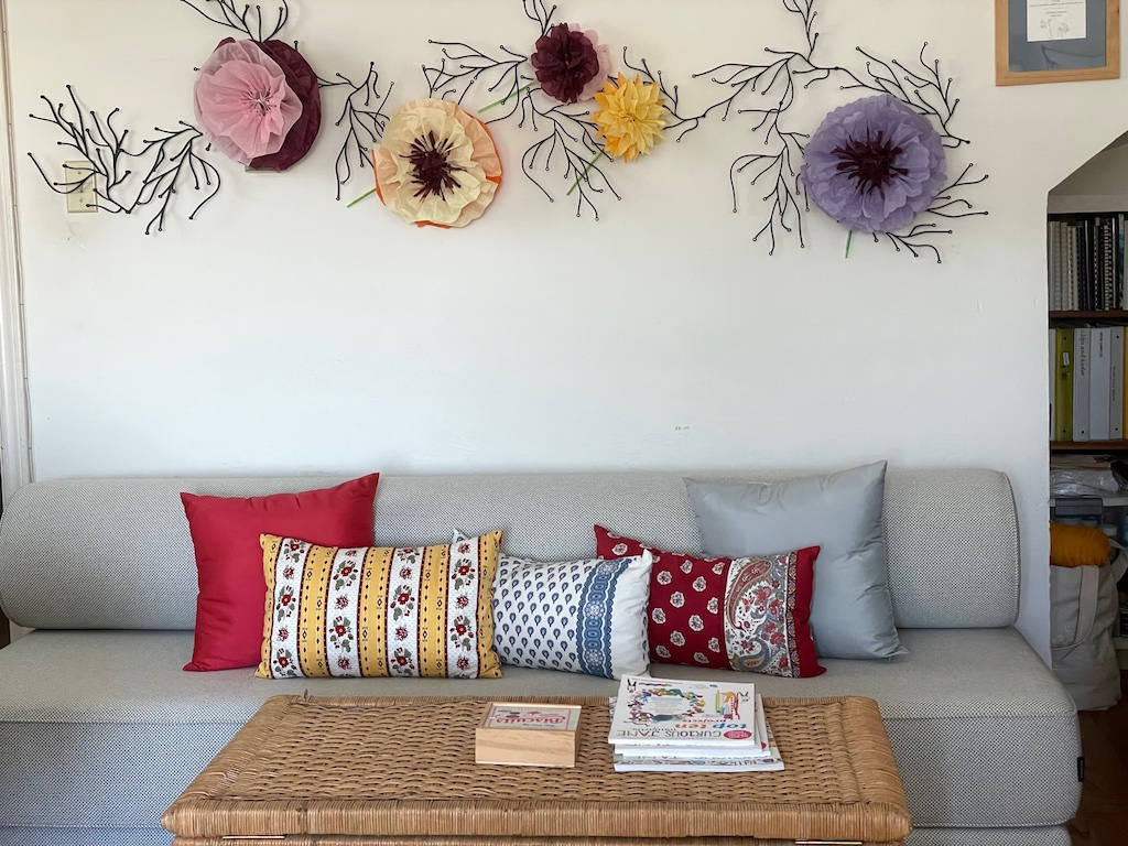 Mexican paper flowers integrated into existing wall sculpture.