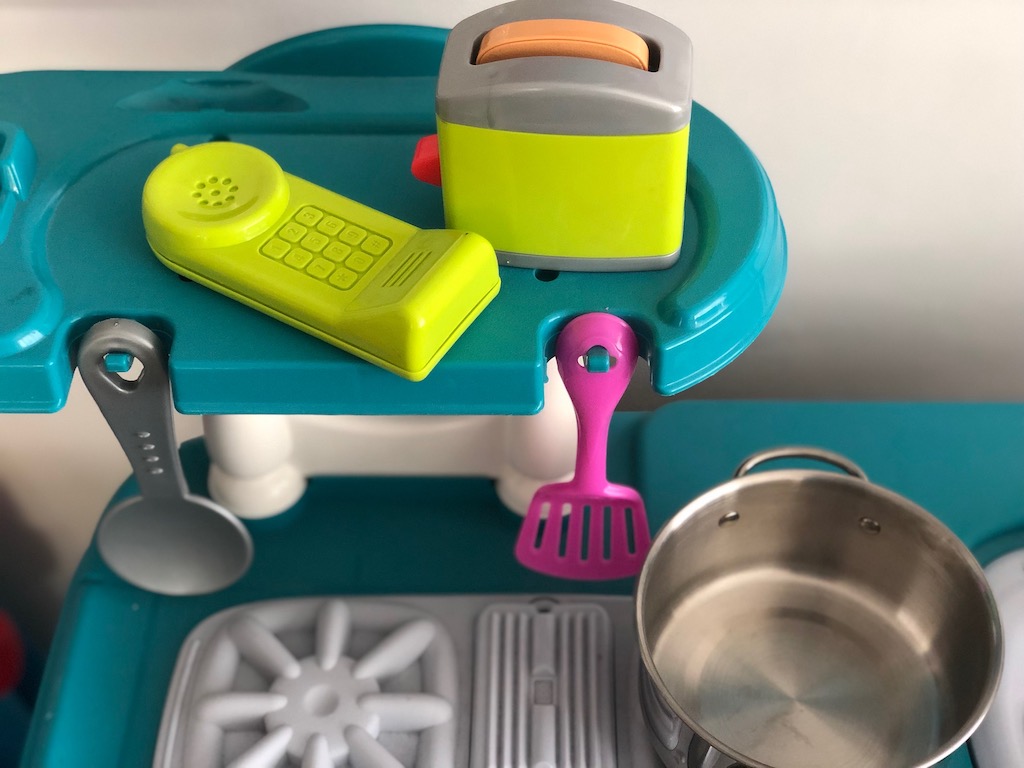 Kitchen set with toy phone, toaster, and stainless steel pot. 