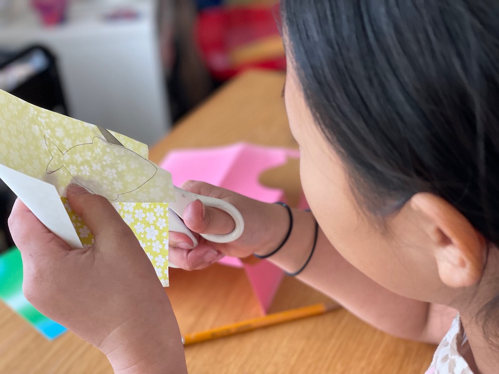 Cut through both thicknesses of origami paper to make two fish that you will glue together.