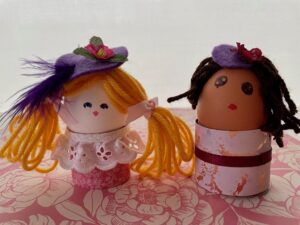 These two dolls are made with empty, blown-out eggshells and scraps of yarn, lace, and fabric.