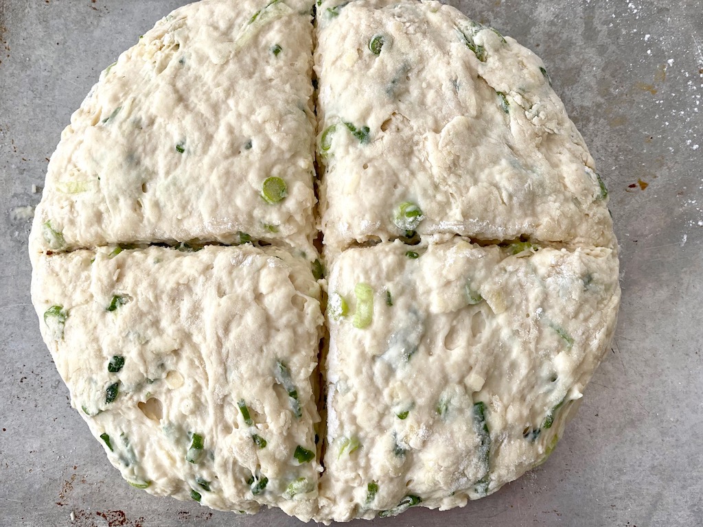 Shape the dough for easy Irish soda bread into a disk and cut a cross through the middle.