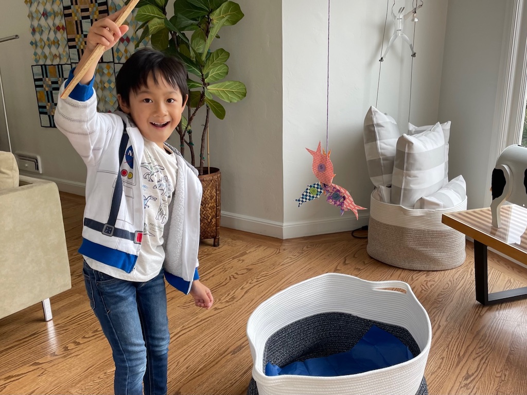 Child catches paper fish. A fun game when indoor play is the order of the day.