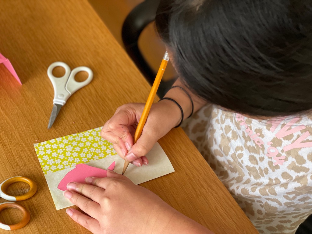 Trace fish pattern onto folded origami paper.