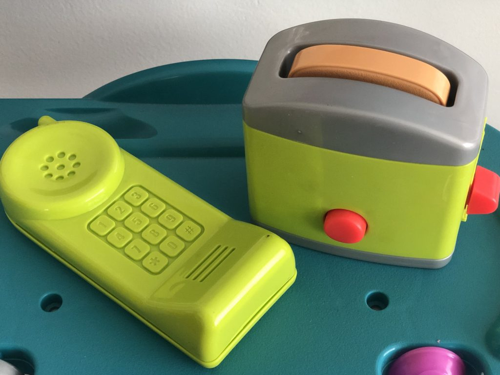 A green toy telephone, part of a kitchen play set can be used for imaginary conversations with long-distance grandparents.
