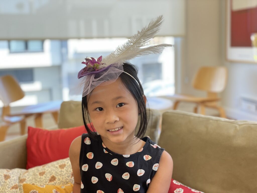 A child models a fascinator she made during Camp Grandma. She'll wear it at a tea party we'll have later.