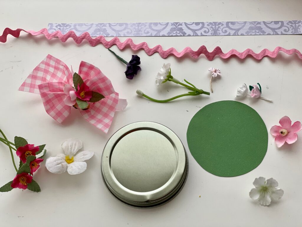 Decorative items to dress up a jar for a Mother's Day gift: ribbons, flowers, rickrack and patterned cardstock strips.