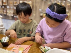Kids make plastic food displays, the kind found in Japanese restaurants, at a class at Osaka, Japan.