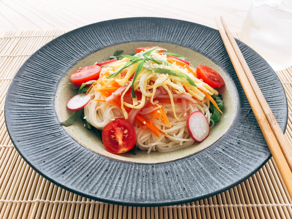 Cold Noodle bowl is made in minutes, the perfect easy summer recipe. Condiments are deli ham, carrots, radishes, cherry tomatoes, green onion and a thin, 1-egg omelet, shredded.