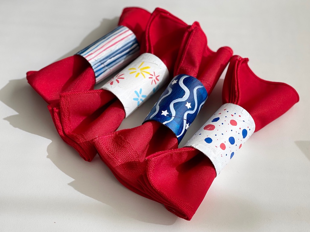 Napkin rings made from gift wrap tubes, are decorated for the Fourth of July.