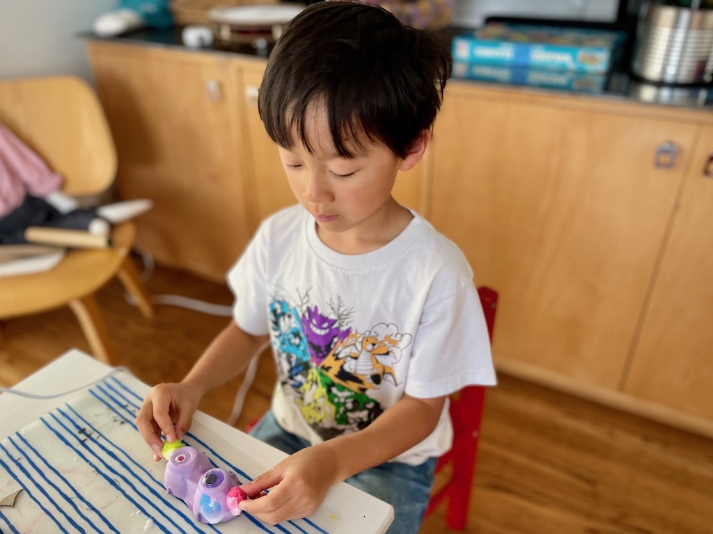 Child makes a puppet from egg carton cups.