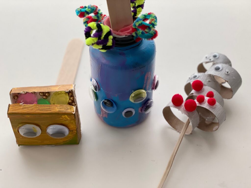 Puppets made from recycle trash. To secure the handle to a puppet made from a plastic jar, glue felt strips to the mouth of the bottle, then glue the handle to the felt.