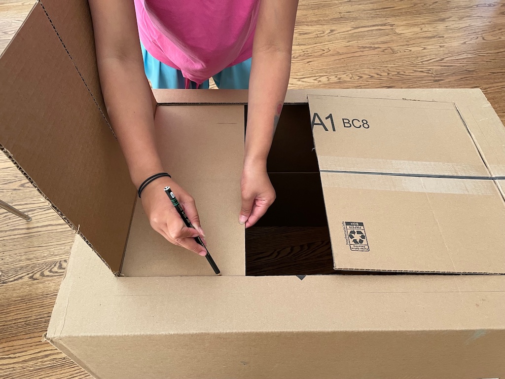 Trim the box flaps that block the opening of the puppet theater.