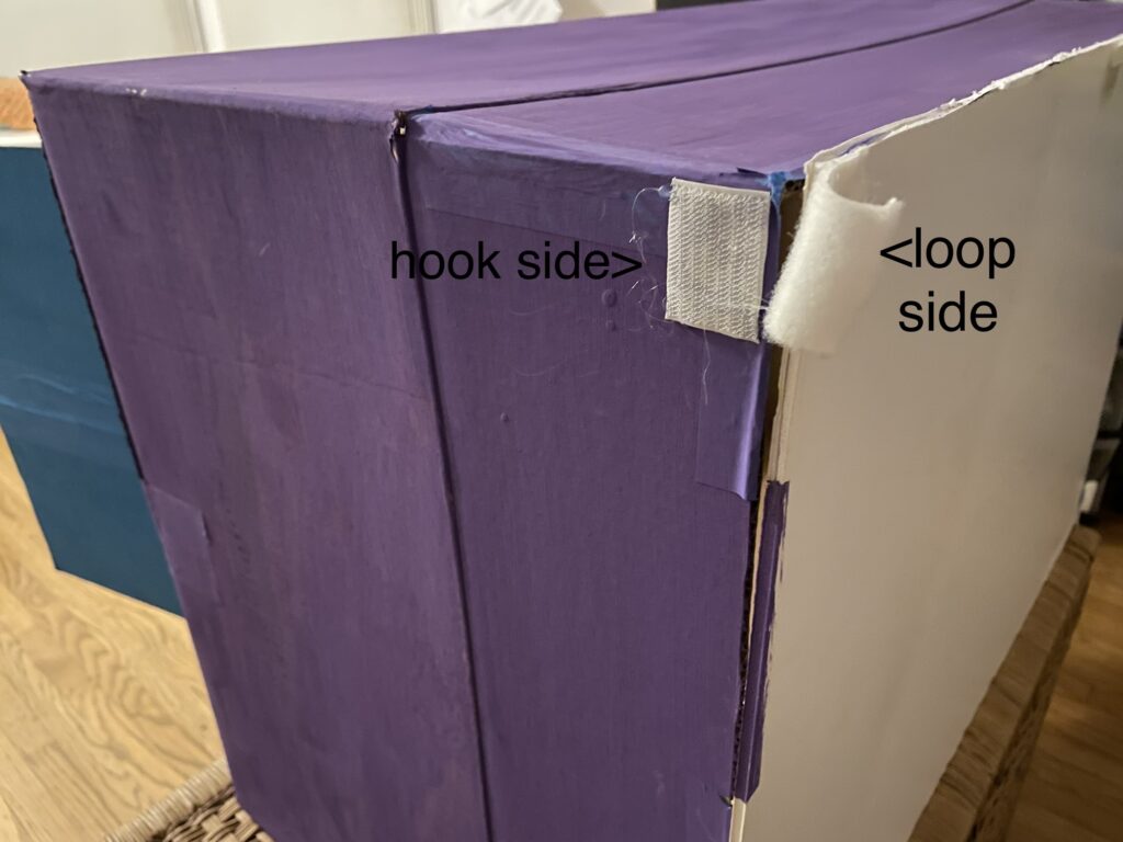 Attach the velcro with hook side to the puppet theater and loop side to the cardboard backing.