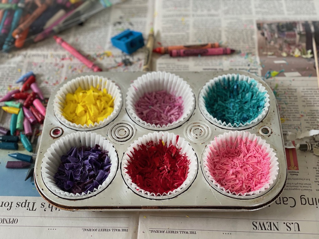 Crayon is shaved with pencil sharpener and put in paper-lined muffin tins for melted crayon art.