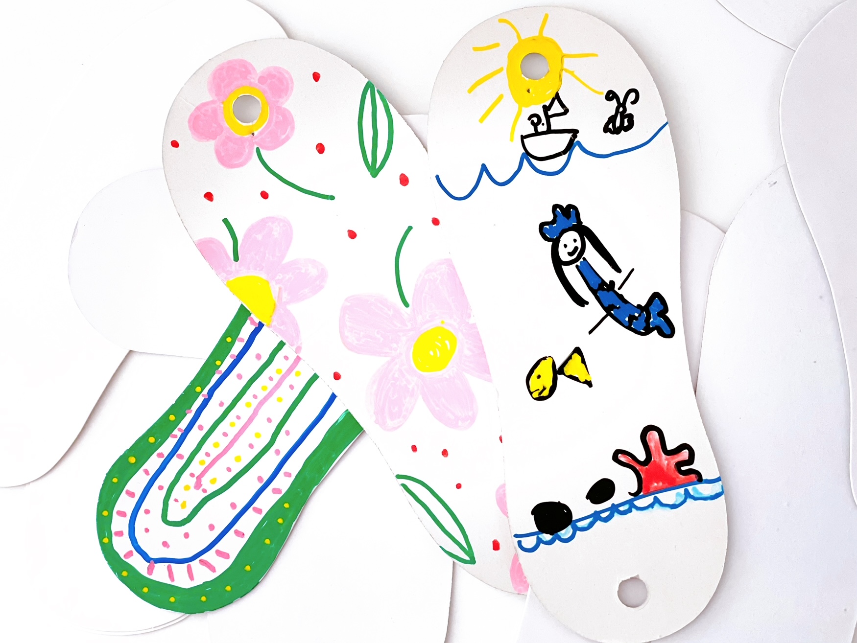 Cardboard feet from sox packaging is decorated with colorful designs using markers. They make great wall art.