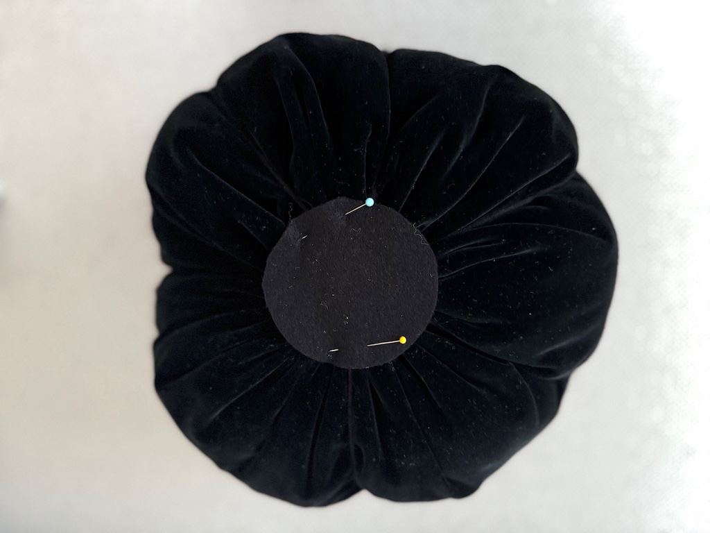 Pin a felt circle to the bottom of the pumpkin to cover hole and gathers. Stitch in place.