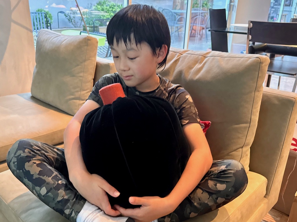 Child hugs a pumpkin pillow. These pillows are soft and perfect for cuddling with.